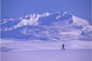 A lone traveler hikes through the tundra landscape