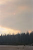 Un incendie donne au soleil des teintes rouges au travers des nuages de fumée.